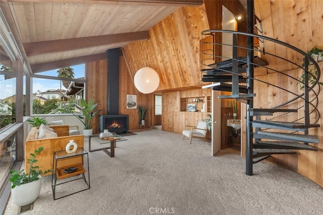 living room with a wood stove, wood walls, and vaulted ceiling with beams