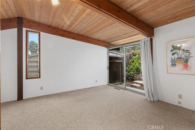 carpeted spare room with wood walls, beamed ceiling, and wood ceiling