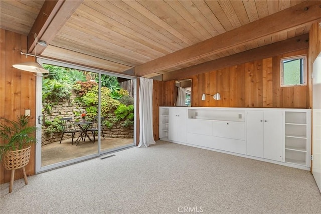 interior space with beam ceiling, wooden ceiling, and wooden walls