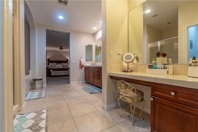 bathroom with tile patterned floors, a shower with door, and vanity