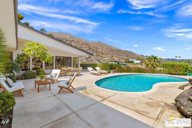 view of swimming pool with a mountain view and a patio