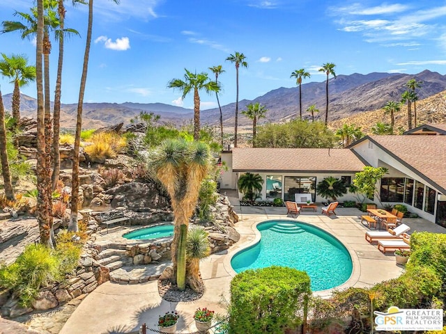 view of swimming pool featuring outdoor lounge area, a mountain view, an in ground hot tub, and a patio