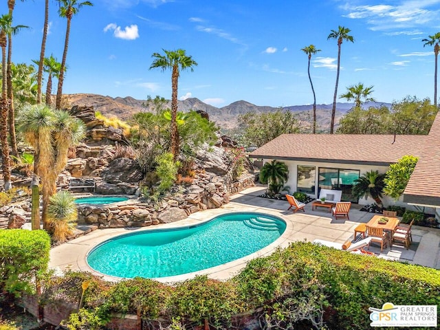 view of pool with an outdoor hangout area, a mountain view, and a patio