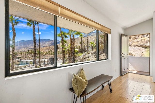 sunroom with vaulted ceiling and a mountain view