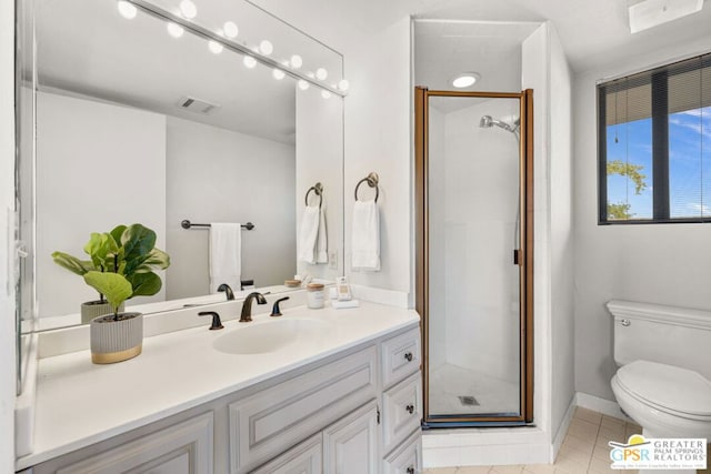 bathroom featuring toilet, tile patterned floors, vanity, and a shower with shower door