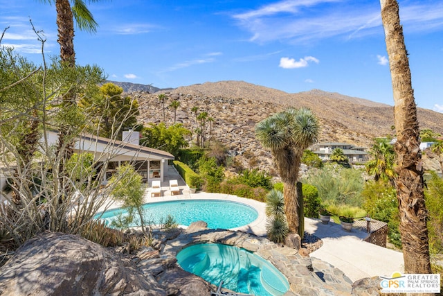 view of pool with a mountain view, a hot tub, and a patio