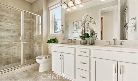 bathroom with vanity, toilet, tile patterned floors, and a shower with shower door