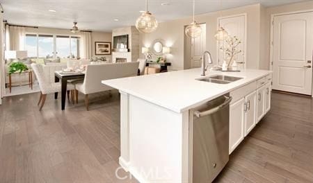 kitchen with pendant lighting, hardwood / wood-style flooring, a kitchen island with sink, white cabinets, and stainless steel dishwasher