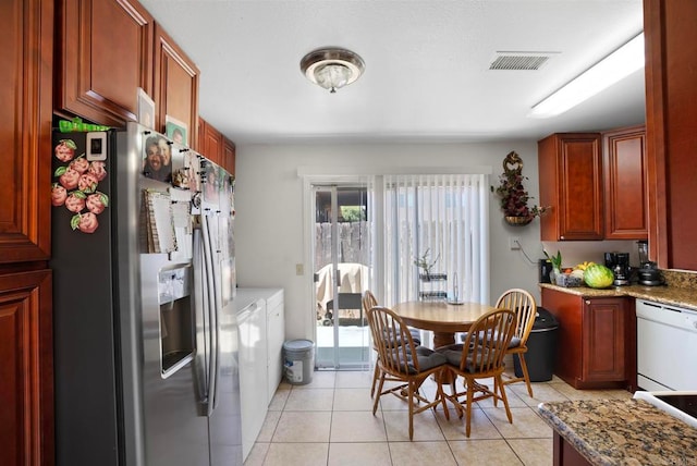 kitchen featuring stainless steel refrigerator with ice dispenser, light stone countertops, light tile patterned floors, and dishwasher