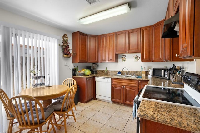 kitchen with dark stone countertops, light tile patterned flooring, white dishwasher, sink, and electric range