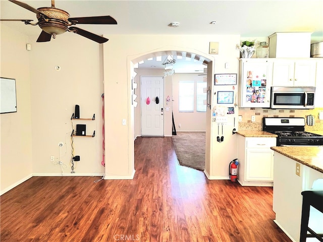 kitchen featuring black range with gas stovetop, white cabinetry, and dark hardwood / wood-style floors