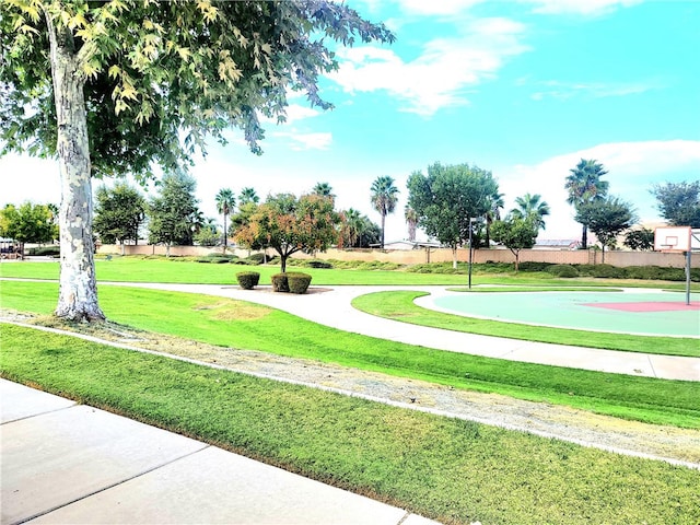 surrounding community featuring a yard and basketball court