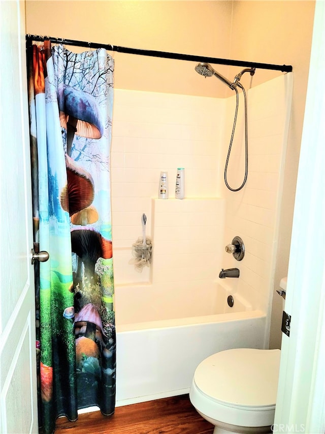 bathroom featuring shower / bath combination with curtain, hardwood / wood-style flooring, and toilet