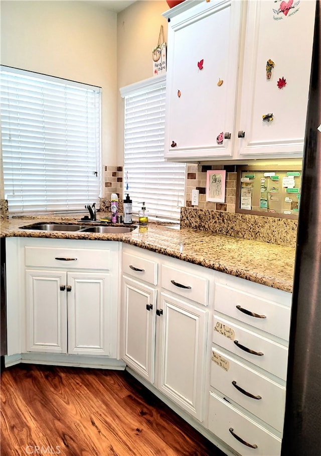 kitchen featuring tasteful backsplash, dark hardwood / wood-style flooring, sink, light stone countertops, and white cabinetry