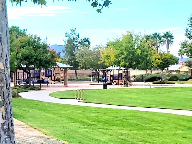 view of home's community featuring a playground and a yard