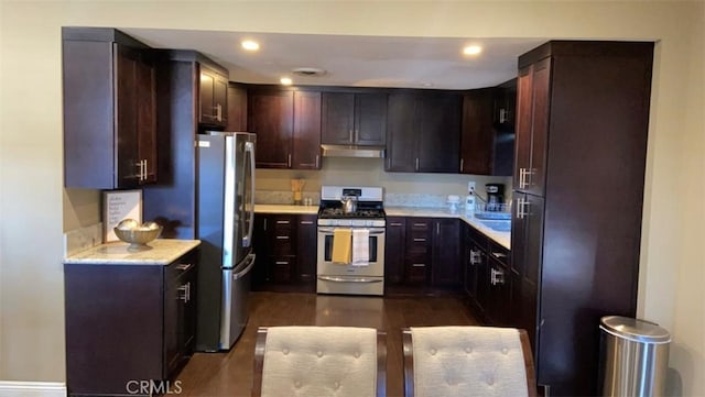 kitchen with appliances with stainless steel finishes, dark brown cabinetry, and dark hardwood / wood-style floors