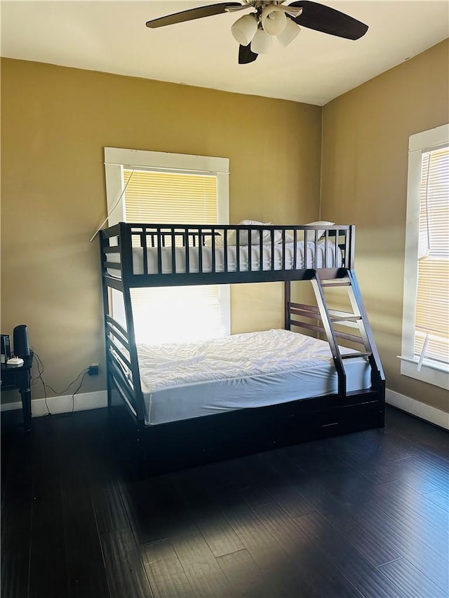 bedroom with dark hardwood / wood-style floors and ceiling fan