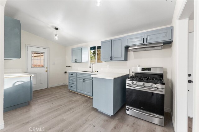 kitchen with stainless steel gas range, sink, light hardwood / wood-style flooring, and vaulted ceiling