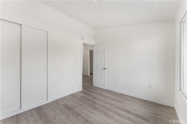 unfurnished bedroom with a closet and light hardwood / wood-style floors