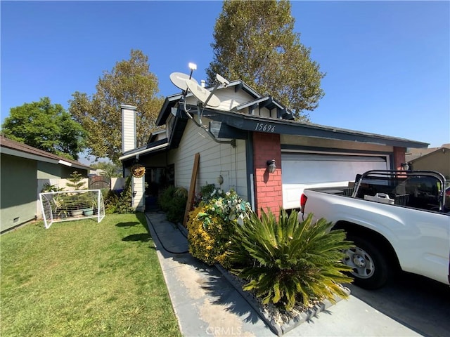 view of side of home with a garage, a chimney, and a lawn