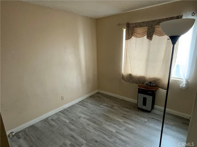 empty room featuring baseboards and wood finished floors