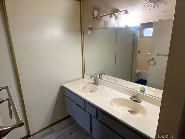 full bathroom with a sink, toilet, and double vanity