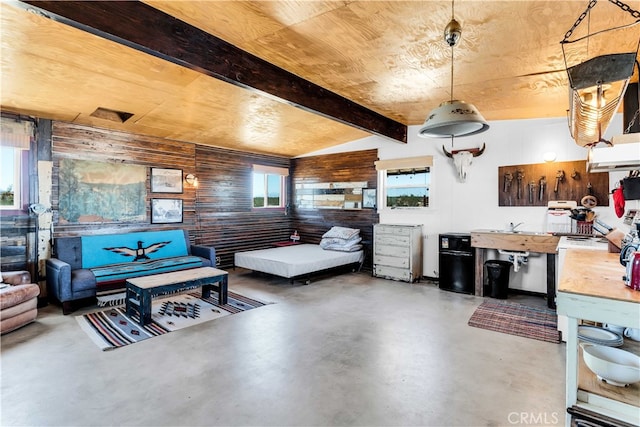 interior space with vaulted ceiling with beams, wood walls, concrete floors, and wooden ceiling