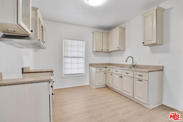 kitchen featuring light wood-type flooring, sink, and cream cabinets