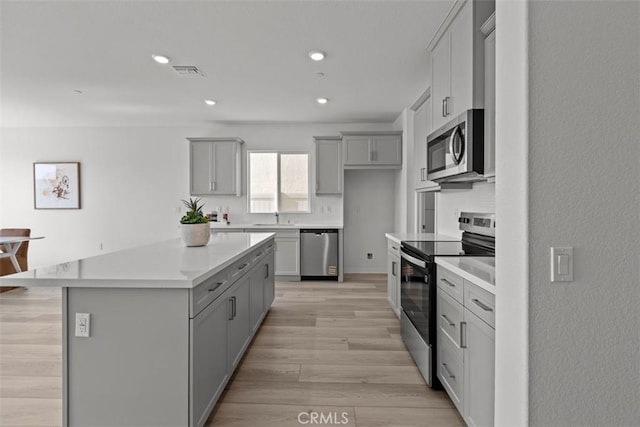 9665 Larimar Ct, Riverside, CA 92508 - kitchen featuring a sink, gray cabinetry, a center island, and appliances with stainless steel finishes