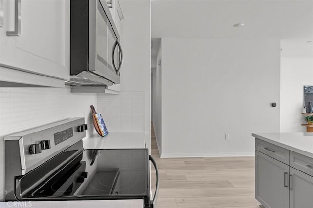 9665 Larimar Ct, Riverside, CA 92508 - kitchen featuring light wood-style flooring, backsplash, light countertops, appliances with stainless steel finishes, and gray cabinets