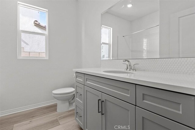 9665 Larimar Ct, Riverside, CA 92508 - full bathroom with toilet, wood finished floors, baseboards, backsplash, and vanity