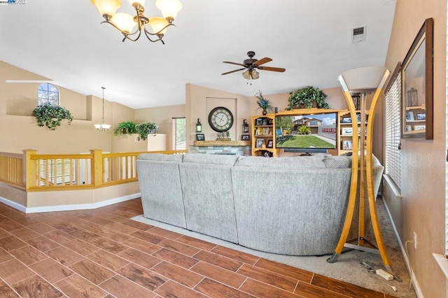 unfurnished living room with ceiling fan with notable chandelier and vaulted ceiling