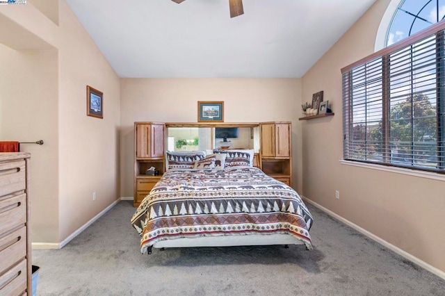 bedroom with light carpet, multiple windows, ceiling fan, and lofted ceiling