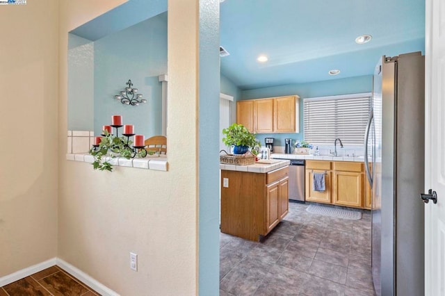 kitchen featuring light brown cabinets, sink, stainless steel appliances, kitchen peninsula, and tile countertops