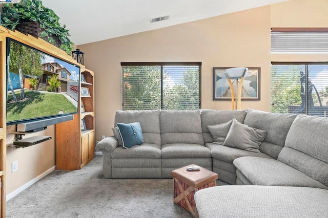 living room featuring lofted ceiling, a wealth of natural light, and light colored carpet