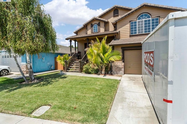 view of front of house featuring covered porch, a front yard, and a garage