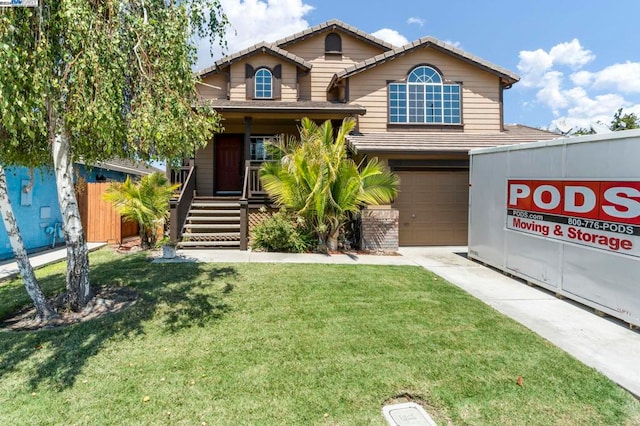 view of front property featuring a front yard, a garage, and a porch