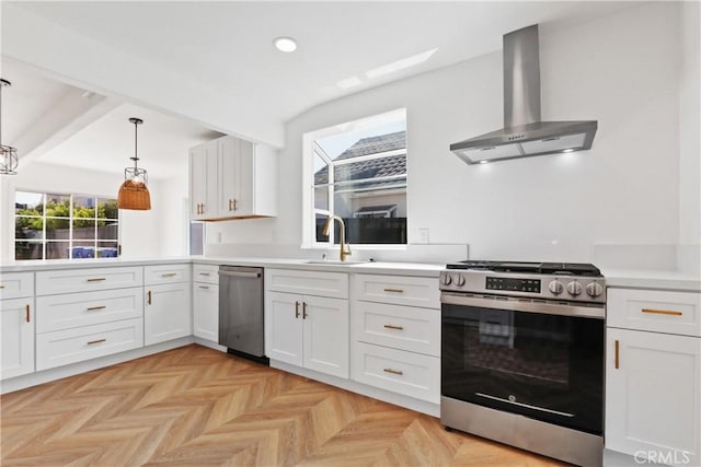 kitchen featuring decorative light fixtures, stainless steel appliances, white cabinetry, and wall chimney exhaust hood