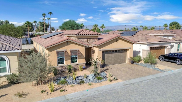 mediterranean / spanish-style home with solar panels and a garage