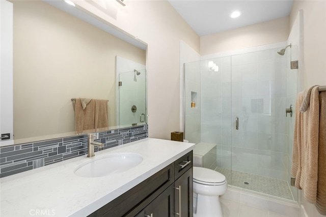 bathroom featuring backsplash, vanity, an enclosed shower, toilet, and tile patterned floors