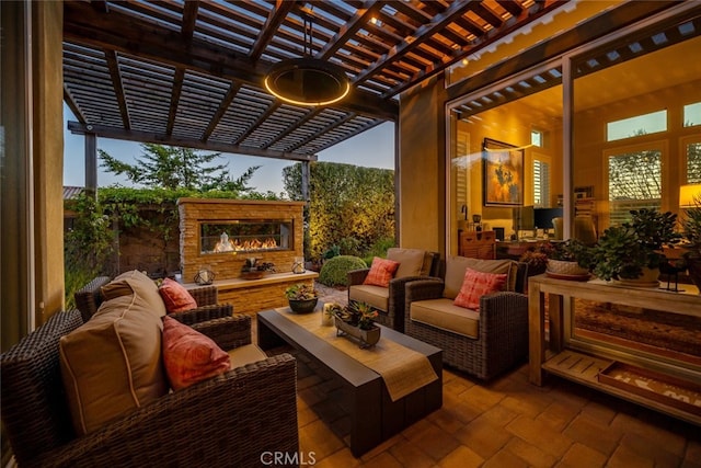 patio terrace at dusk featuring an outdoor living space with a fireplace and a pergola