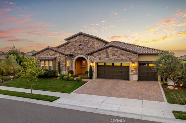 mediterranean / spanish house with a yard and a garage