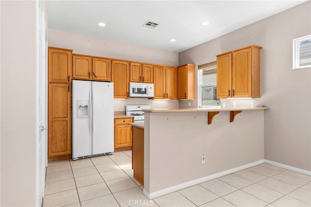 kitchen with white appliances, a peninsula, light countertops, light tile patterned flooring, and visible vents