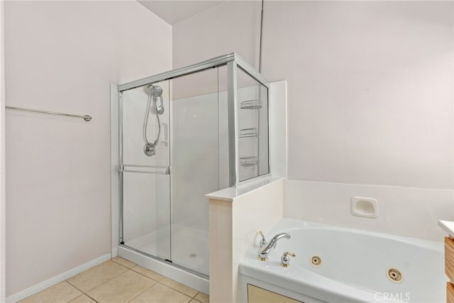 bathroom featuring a stall shower, a jetted tub, and tile patterned floors