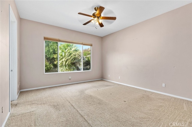 spare room featuring ceiling fan, baseboards, and carpet floors