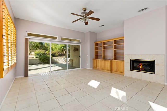 unfurnished living room featuring ceiling fan, light tile patterned flooring, and a tiled fireplace