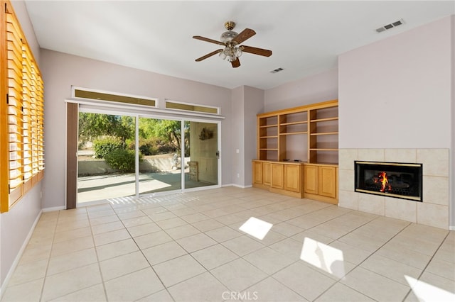 unfurnished living room with ceiling fan, a fireplace, light tile patterned floors, visible vents, and baseboards