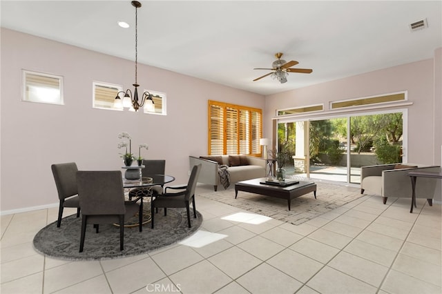 tiled dining room with ceiling fan with notable chandelier