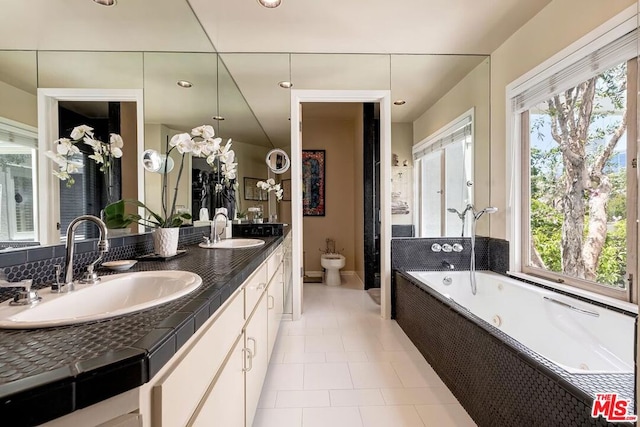 bathroom featuring vanity, toilet, a bath, and a wealth of natural light