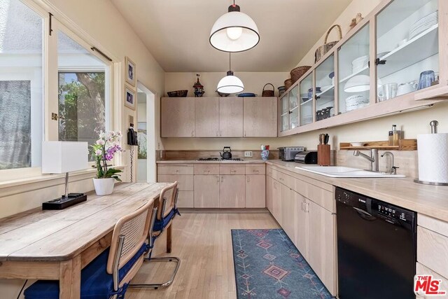 kitchen featuring sink, light brown cabinets, dishwasher, light hardwood / wood-style floors, and hanging light fixtures